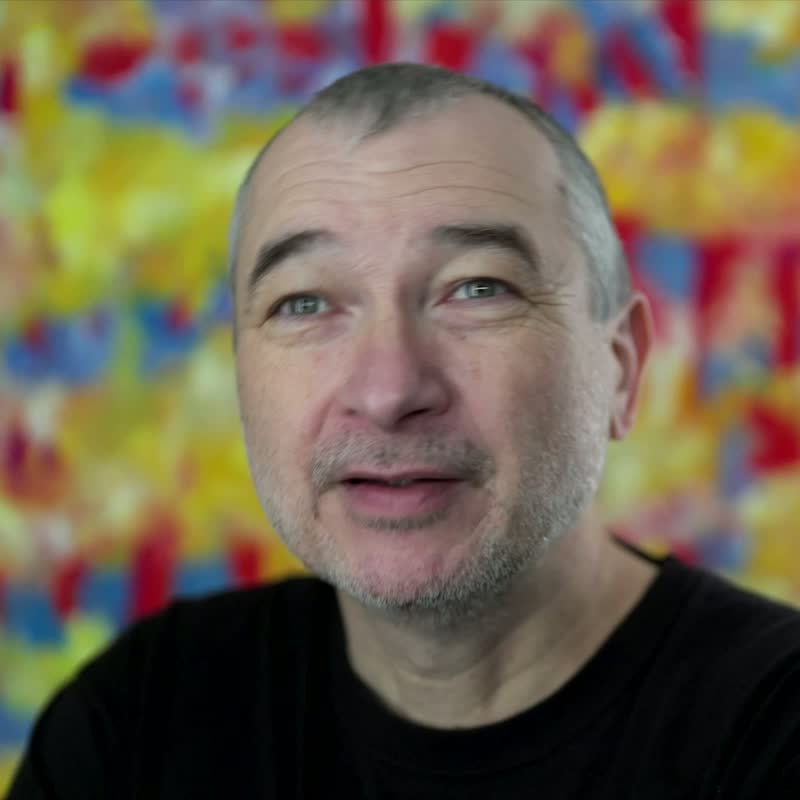 Portrait of Tobias Post against a colourful background